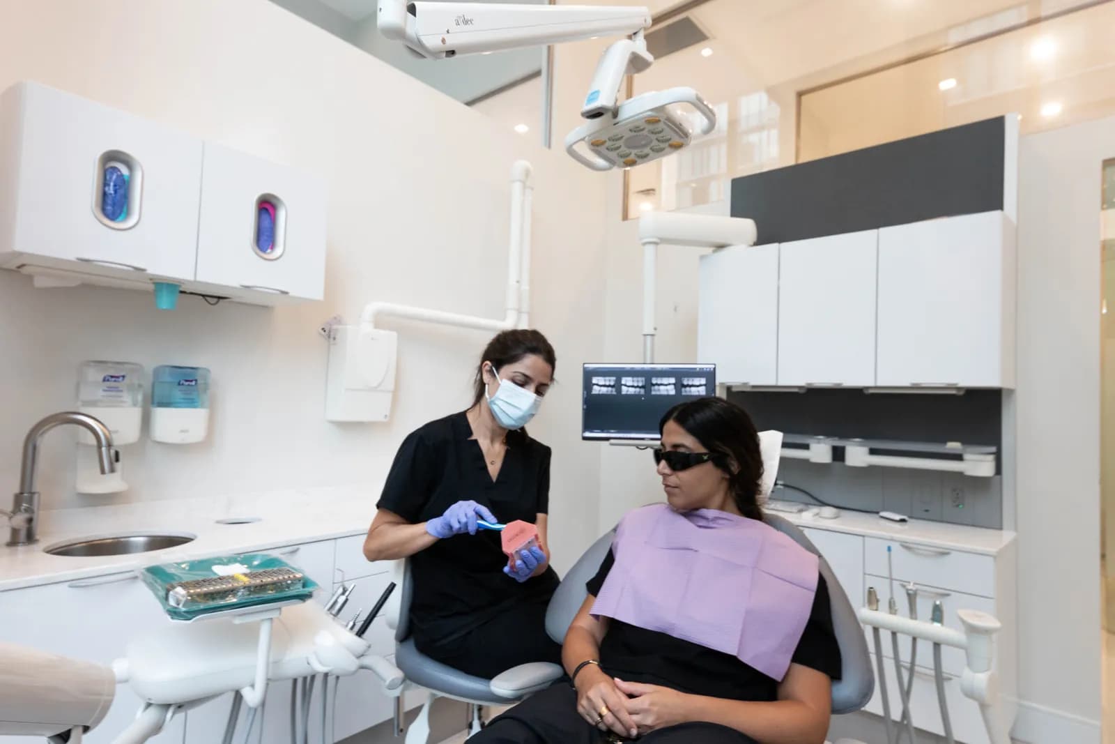 A dental hygienist and patient talking through a smile plan in a treatment room at Dentistry on Gloucester