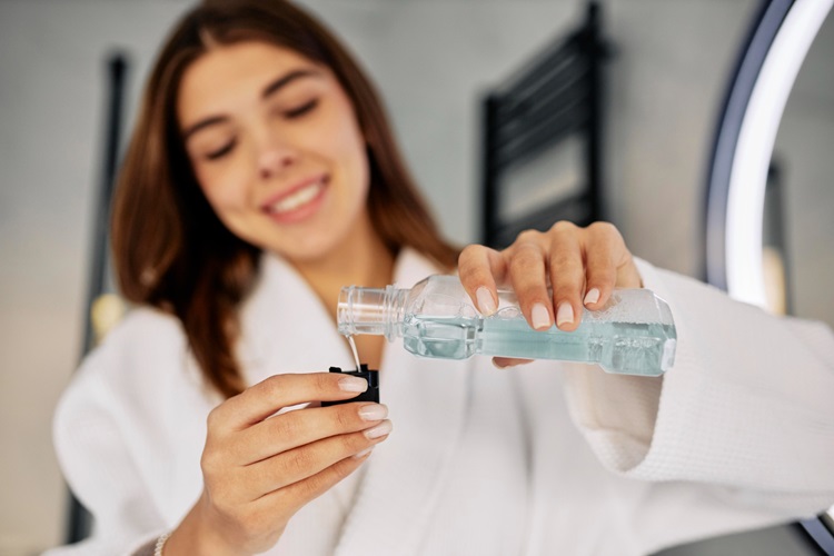 a woman using mouthwash